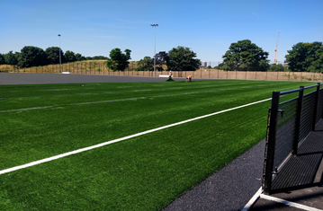 People playing football on green field in Burgess Park 